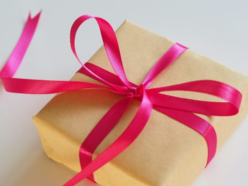 Present wrapped in brown paper and a pink satin bow. Present wrapped in brown paper and a pink satin bow.