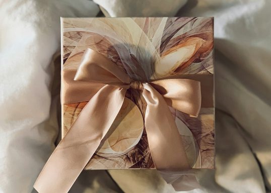 Cream, Gold & Brown gift box tied with a muted apricot satin bow. Cream, Gold & Brown gift box tied with a muted apricot satin bow.